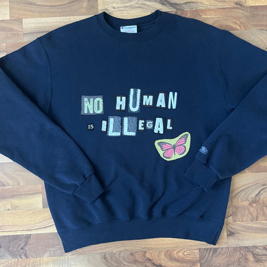 NO HUMAN IS ILLEGAL | M