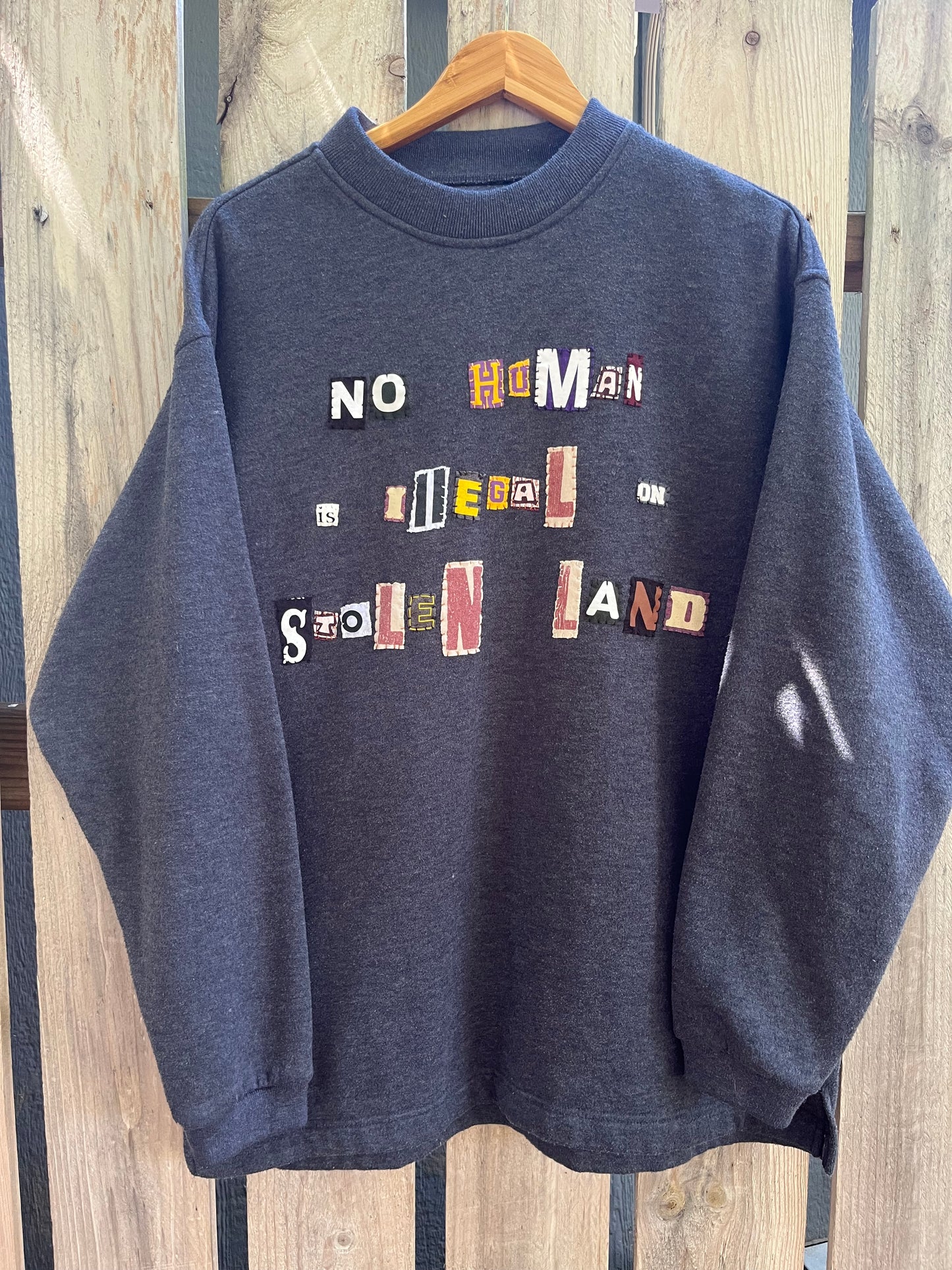 NO HUMAN IS ILLEGAL ON STOLEN LAND Navy Crew | XL